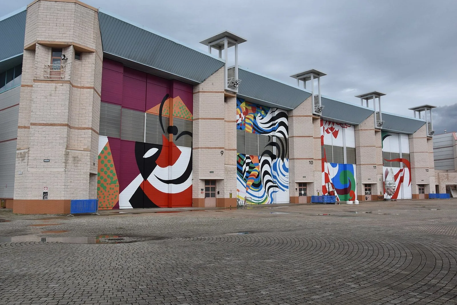Gli hangar della Cittadella del Carnevale di Viareggio con i grandi portoni dipinti a colori vivaci sulla piazza lastricata